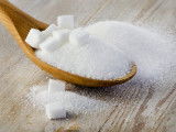 Du sucre blanc dans une cuillère en bois