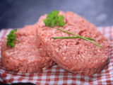 Deux steaks hachés crus sur une nappe