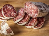 Du saucisson en tranches sur une planche de bois