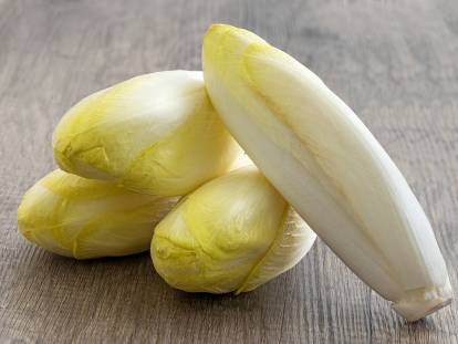 Des endives posées sur un fond en bois