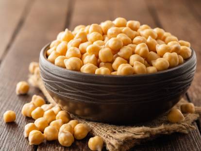 Un bol de pois chiches sur une table en bois