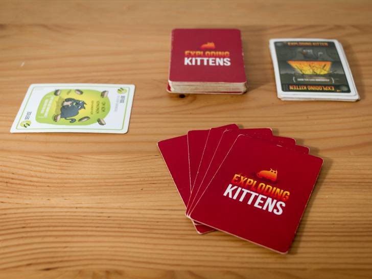 Des cartes du jeu «Exploding Kittens» posées sur une table