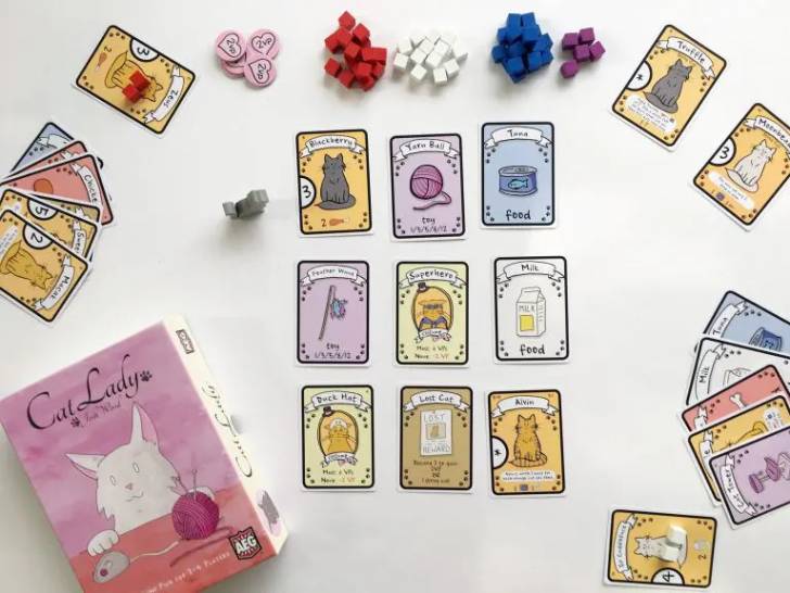 La boîte du jeu «Cat Lady» et ses cartes posées sur une table