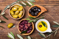 Des olives vertes, noires et violettes dans des bols avec de l'huile