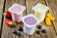 Trois yaourts aux fruits sur un fond en bois