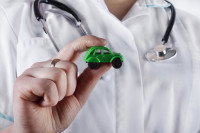Un vétérinaire tenant une petite voiture verte dans sa main