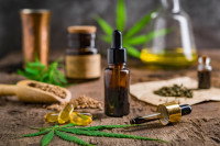 De l'huile de CBD et du cannabis sur une table en bois