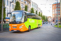 Un car vert et orange roulant en ville