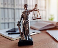 Une petite statue de la déesse de la justice tenant une balance
