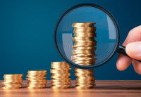 4 piles de pièces de plus en plus grande examinées à la loupe