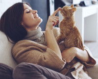 Une femme qui joue avec son chat sur les genoux