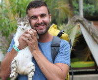 Un campeur qui pose en photo en tenant son chat