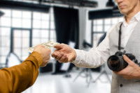 Une personne donnant de l'argent à un photographe