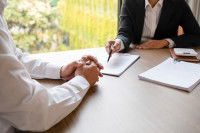 Deux personnes discutant autour d'une table en étudiant un document