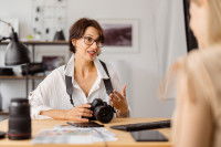 Une photographe, appareil photo à la main, en train de discuter avec une cliente