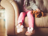 Une fillette assise dans un canapé avec son petit chien