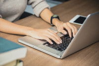 Une femme en train de taper sur un ordinateur portable