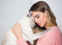 Une femme tenant son chat contre son front