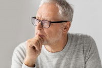 Un homme pense, se tient le menton