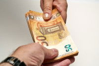 Gros plan sur un échange de billets de 50 euros