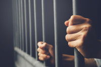 Gros plan sur les mains d'un homme en prison