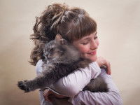 Une jeune femme serrant un chat gris dans ses bras
