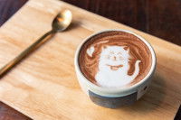 Un chocolat chaud avec un motif de chat dans une tasse