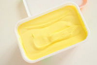 Un pot de margarine avec un couteau