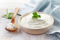 Un fromage blanc dans un bol avec une cuillère en bois