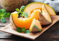 Des tranches de melon sur une table en bois