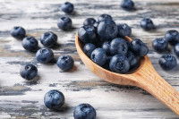 Des myrtilles dans une cuillère en bois