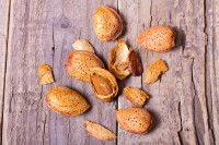 Des amandes fraîches avec leur coque sur une table en bois