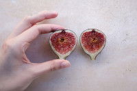 Une main avec une figue coupée en deux