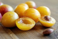 Des mirabelles avec noyau sur une table en bois