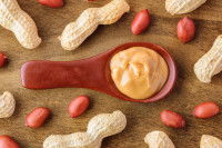 Une cuillère en plastique avec du beurre de cacahuète