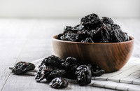 Un bol contenant des pruneaux sur une table
