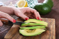 Une femme découpe de l'avocat en tranches