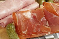 Du jambon cru et blanc sur une table en bois