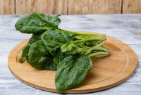 Quelques feuilles d'épinard sur une planche en bois