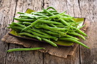 Des haricots verts sur une table en bois