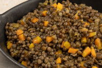 Un plat contenant des lentilles et des morceaux de carotte