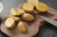 Des pommes de terre coupées en deux sur une planche en bois