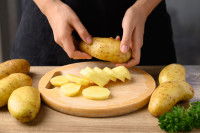 Une femme coupe des pommes de terre en tranches