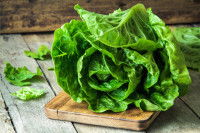 Une grosse laitue posée sur une planche de bois