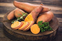 Des patates douces posées sur une planche de bois