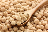 Une cuillère en bois contenant des pois chiches