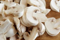 Des champignons de Paris coupés en deux sur une table