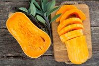 Des tranches de butternut sur une planche de cuisine