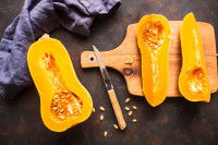 Des butternuts coup&eacute;s en deux sur une planche de cuisine