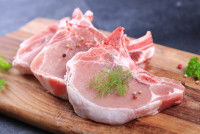 Des morceaux de viande de boeuf crue sur une planche de bois